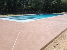 Tan swirl finished concrete decking for swimming pools